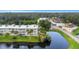 Aerial view of condo complex with a pond, pool, and parking, set amid lush landscaping at 940 Virginia St # 303, Dunedin, FL 34698