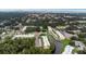 Aerial view of condo complex surrounded by lush greenery, a pond, and various amenities at 940 Virginia St # 303, Dunedin, FL 34698