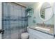 Bathroom featuring a granite-topped sink, a matching framed mirror and a shower with a beach-themed curtain at 940 Virginia St # 303, Dunedin, FL 34698