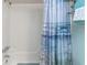 Bathroom featuring a shower-tub combination with a beach-themed curtain and a set of towel racks at 940 Virginia St # 303, Dunedin, FL 34698