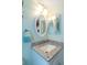 Bathroom showcasing a granite-topped sink with framed mirror in a space with bright and fresh color at 940 Virginia St # 303, Dunedin, FL 34698