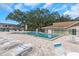 Community pool surrounded by lounge chairs and green trees, perfect for relaxation and recreation at 940 Virginia St # 303, Dunedin, FL 34698