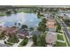 Aerial view of a house with a pool on a lake in a densely populated suburban neighborhood at 31111 Bridgegate Dr, Wesley Chapel, FL 33545