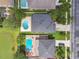 Aerial view of home with dark roof, yard with a kidney-shaped pool, and nearby pond for an outdoor lifestyle at 31111 Bridgegate Dr, Wesley Chapel, FL 33545