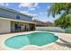Inviting backyard featuring a freeform pool, covered patio, and well-manicured landscaping at 31111 Bridgegate Dr, Wesley Chapel, FL 33545