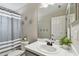 Neutral bathroom featuring a shower with grey striped curtain and white countertop sink at 31111 Bridgegate Dr, Wesley Chapel, FL 33545