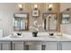 This bathroom offers dual sinks, chrome fixtures, decorative mirrors, and sleek gray cabinets at 31111 Bridgegate Dr, Wesley Chapel, FL 33545