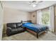 Bedroom with a leather couch, fan, window, and bed at 31111 Bridgegate Dr, Wesley Chapel, FL 33545