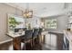 Elegant dining room with modern lighting, hardwood floors, and large windows, creating an inviting atmosphere at 31111 Bridgegate Dr, Wesley Chapel, FL 33545