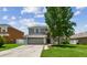 Charming two-story home with a well-maintained lawn, large tree, and neutral-colored facade, featuring a two-car garage at 31111 Bridgegate Dr, Wesley Chapel, FL 33545