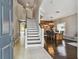 Bright foyer featuring a staircase, tiled floors, and an open view into the dining area with hardwood floors at 31111 Bridgegate Dr, Wesley Chapel, FL 33545