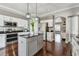 Well-equipped kitchen with stainless steel appliances, an island, dark countertops, and bright white cabinetry at 31111 Bridgegate Dr, Wesley Chapel, FL 33545