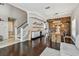 Cozy living space with a staircase, hardwood floors, and an open layout that flows into the adjacent dining area at 31111 Bridgegate Dr, Wesley Chapel, FL 33545