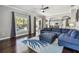 Open concept living room with dark wood floors and large comfortable blue sectional sofa and ottoman at 31111 Bridgegate Dr, Wesley Chapel, FL 33545