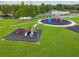 Aerial view of modern playground, featuring colorful play structures, soft landing and outdoor fun at 31111 Bridgegate Dr, Wesley Chapel, FL 33545