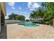 Lush landscaping surrounds the large pool and brick paver patio, creating a private backyard retreat at 31111 Bridgegate Dr, Wesley Chapel, FL 33545