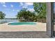 Beautiful kidney-shaped pool surrounded by brick pavers and lush landscaping with serene lake views at 31111 Bridgegate Dr, Wesley Chapel, FL 33545