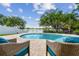 Inviting backyard pool with serene lake view and lush landscaping, perfect for relaxation and outdoor entertaining at 31111 Bridgegate Dr, Wesley Chapel, FL 33545