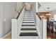 Elegant staircase featuring dark wood treads and white risers and banisters at 31111 Bridgegate Dr, Wesley Chapel, FL 33545
