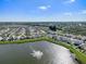 Aerial view of a community showing houses surrounding a scenic lake with a fountain at 10024 Merry Fawn Ct, Sun City Center, FL 33573
