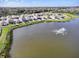 Aerial view of a scenic lake with a fountain surrounded by houses in a community at 10024 Merry Fawn Ct, Sun City Center, FL 33573