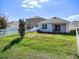 Spacious backyard boasts lush grass, complemented by a white fence and rear patio at 10024 Merry Fawn Ct, Sun City Center, FL 33573