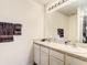Bathroom featuring double sinks and shower with dark palm tree curtain at 10024 Merry Fawn Ct, Sun City Center, FL 33573