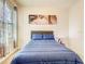 Cozy bedroom featuring a plush blue bed, window with blinds, and modern artwork at 10024 Merry Fawn Ct, Sun City Center, FL 33573