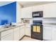 Well-equipped kitchen featuring white cabinets, modern appliances and a stainless steel sink at 10024 Merry Fawn Ct, Sun City Center, FL 33573