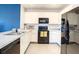 Spacious kitchen equipped with modern appliances and sleek white cabinetry, and a view of the living area at 10024 Merry Fawn Ct, Sun City Center, FL 33573