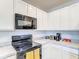 Contemporary kitchen featuring ample countertop space, black appliances, and crisp white cabinetry at 10024 Merry Fawn Ct, Sun City Center, FL 33573