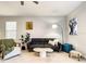 Comfortable living room featuring a gray sofa, modern art, and leafy plants at 10024 Merry Fawn Ct, Sun City Center, FL 33573