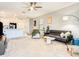 Spacious living room with plush carpeting and adjacent kitchen creating an open-concept living space at 10024 Merry Fawn Ct, Sun City Center, FL 33573