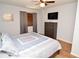 Bright bedroom with ceiling fan, light walls, and dark wood dresser with television at 10265 Gandy N Blvd # 1409, St Petersburg, FL 33702