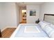 Large bedroom view showing ensuite bathroom, painting on the wall, and wood-look flooring at 10265 Gandy N Blvd # 1409, St Petersburg, FL 33702