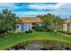 Exterior shot of a two story condo with well maintained lawn and pond on a sunny day at 10265 Gandy N Blvd # 1409, St Petersburg, FL 33702