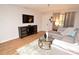 Inviting living room with comfortable gray sofa, wood floors, and entertainment center at 10265 Gandy N Blvd # 1409, St Petersburg, FL 33702