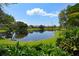 Scenic view of pond surrounded by lush greenery and condominiums under a bright blue sky with clouds at 10265 Gandy N Blvd # 1409, St Petersburg, FL 33702