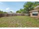 Expansive backyard features a mix of grass and ground cover, enclosed by a combination of wood and vinyl fencing at 10336 Alice M Ct, Port Richey, FL 34668