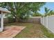 A backyard featuring a large tree, a mix of lawn and dirt areas, surrounded by wood and vinyl fencing at 10336 Alice M Ct, Port Richey, FL 34668