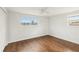 Bedroom featuring hardwood floors, white walls, a ceiling fan, and lots of natural light at 10336 Alice M Ct, Port Richey, FL 34668