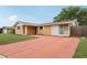Charming single-story home with a spacious front yard and an extended red driveway at 10336 Alice M Ct, Port Richey, FL 34668