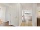 Hallway view to a bright open living area with hardwood floors and ceiling fan at 10336 Alice M Ct, Port Richey, FL 34668