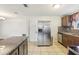 Modern kitchen with stainless steel refrigerator, granite counters, and tiled floors at 10336 Alice M Ct, Port Richey, FL 34668