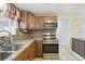 Well-lit kitchen featuring granite counters, mosaic backsplash, stainless appliances, and tile flooring at 10336 Alice M Ct, Port Richey, FL 34668
