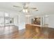 Open-concept living room with hardwood floors, abundant natural light, and kitchen view at 10336 Alice M Ct, Port Richey, FL 34668