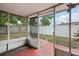 View of an enclosed patio featuring a painted concrete floor, screen walls, and access to a spacious fenced backyard at 10336 Alice M Ct, Port Richey, FL 34668