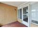 An enclosed patio showcasing a painted concrete floor, access door, and window, with a view of the backyard at 10336 Alice M Ct, Port Richey, FL 34668