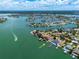 Panoramic aerial shot captures waterfront homes with docks and boat, surrounded by stunning turquoise water at 1135 81St S St, St Petersburg, FL 33707