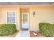 Close-up of a home's front door with decorative plants, a welcome mat, and tidy landscaping at 11511 113Th St # 33D, Largo, FL 33778